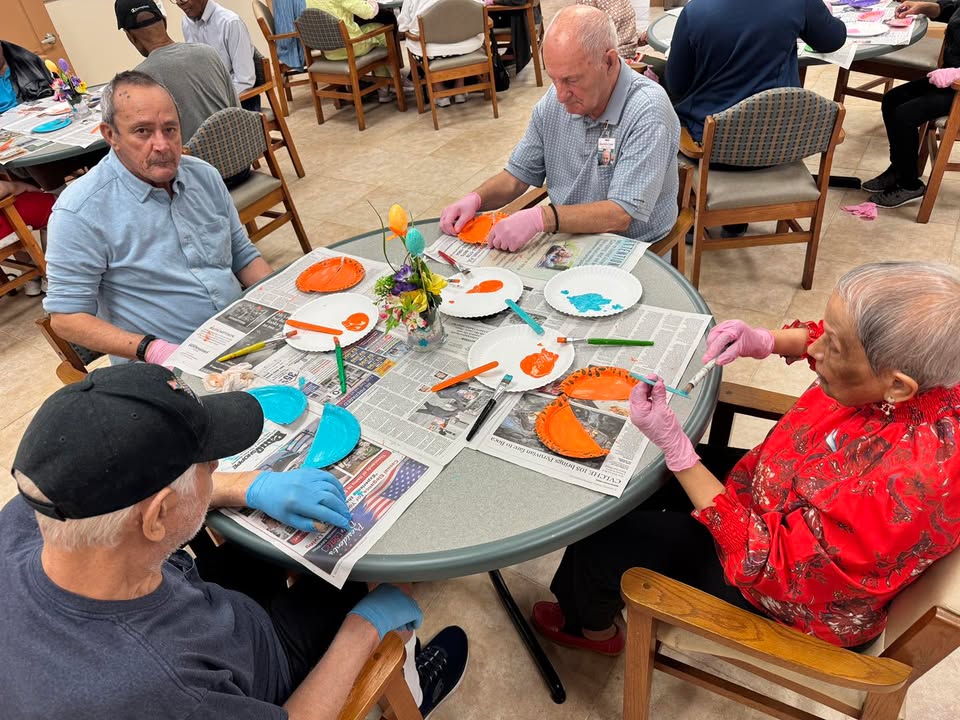 Participants working on a painting project with staff at SarahCare