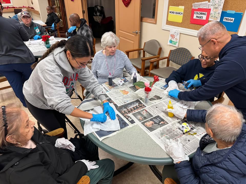 Staff member assisting participants with a craft project at SarahCare