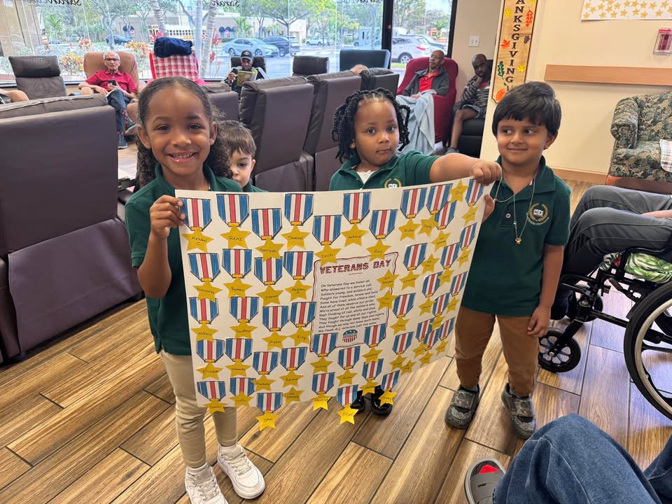 Children presenting a Veterans Day banner to participants at SarahCare